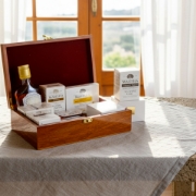 Elenianna luxury Chios mastiha gift box with liqueur and supplements, presented on a linen tablecloth in a sunlit Mediterranean home, highlighting natural wellness.