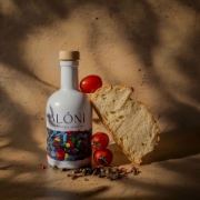 ALÓNI 'The Grove' Limited Edition EVOO bottle with collectible art by Greek artist Soteur shown next to its matching gift box